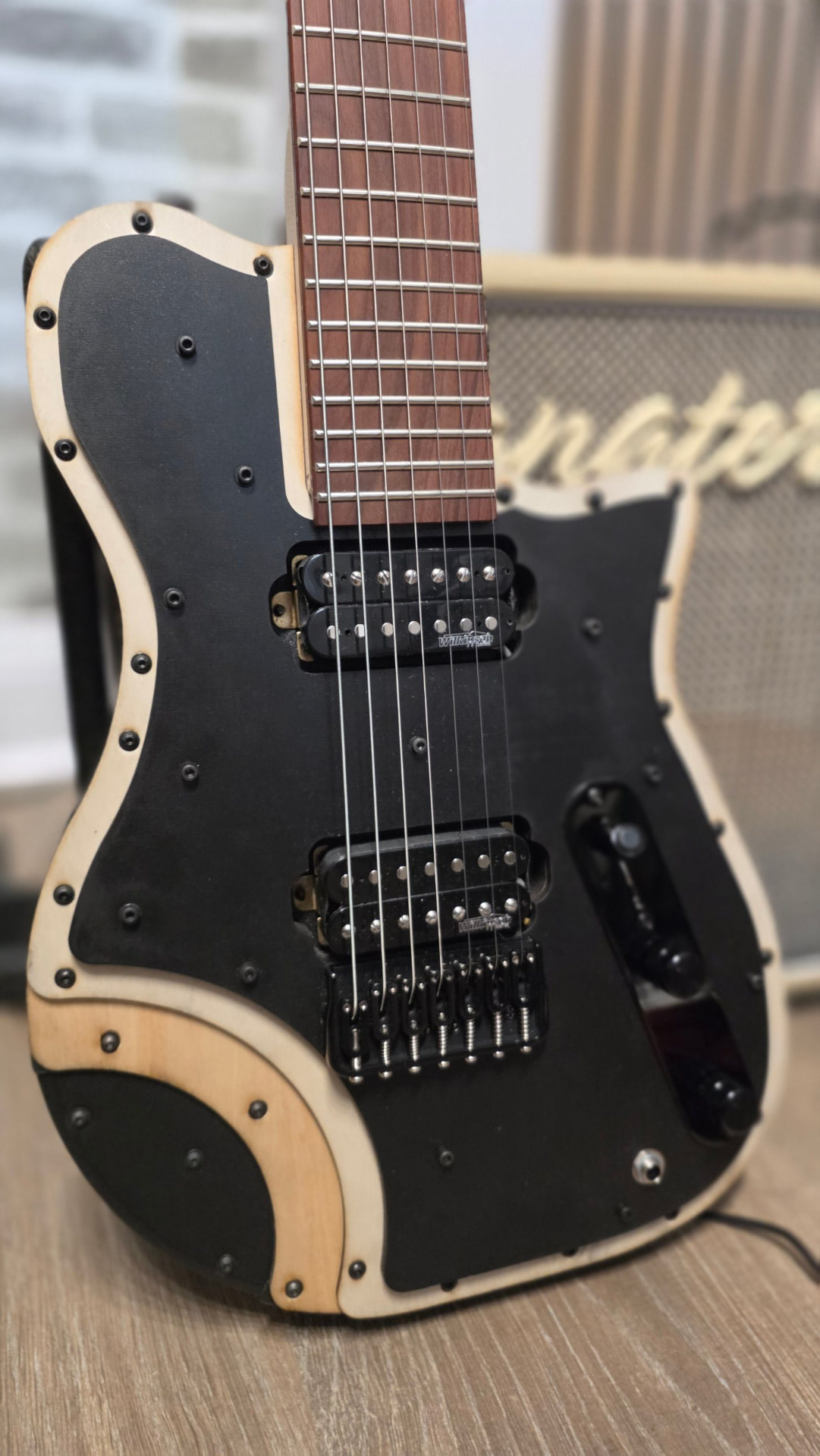 E75 LZR body and two humbuckers resting on a wooden floor